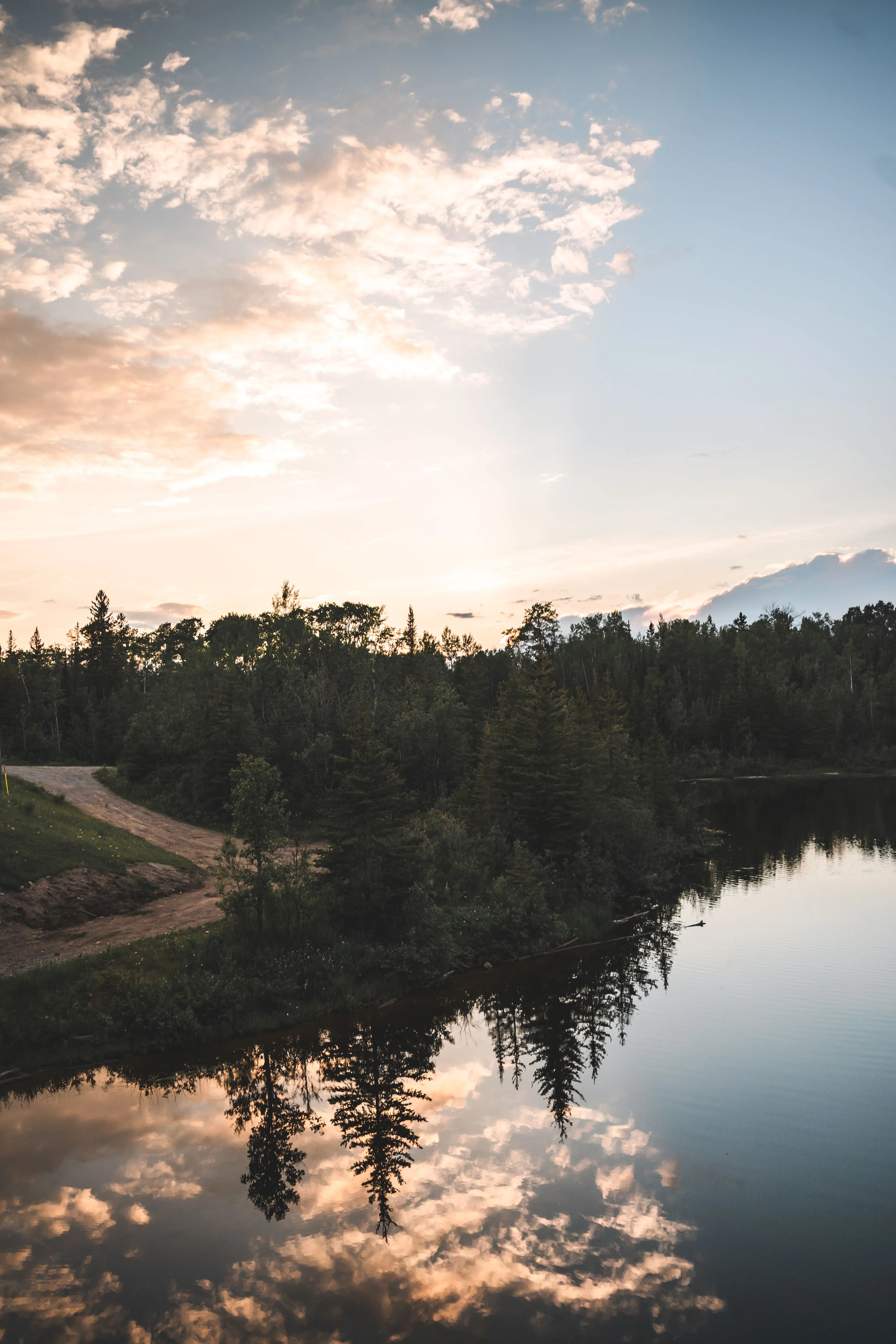 Peaceful lake reflection during sunset in Smooth Rock Falls, Ontario, showcasing nature's beauty.