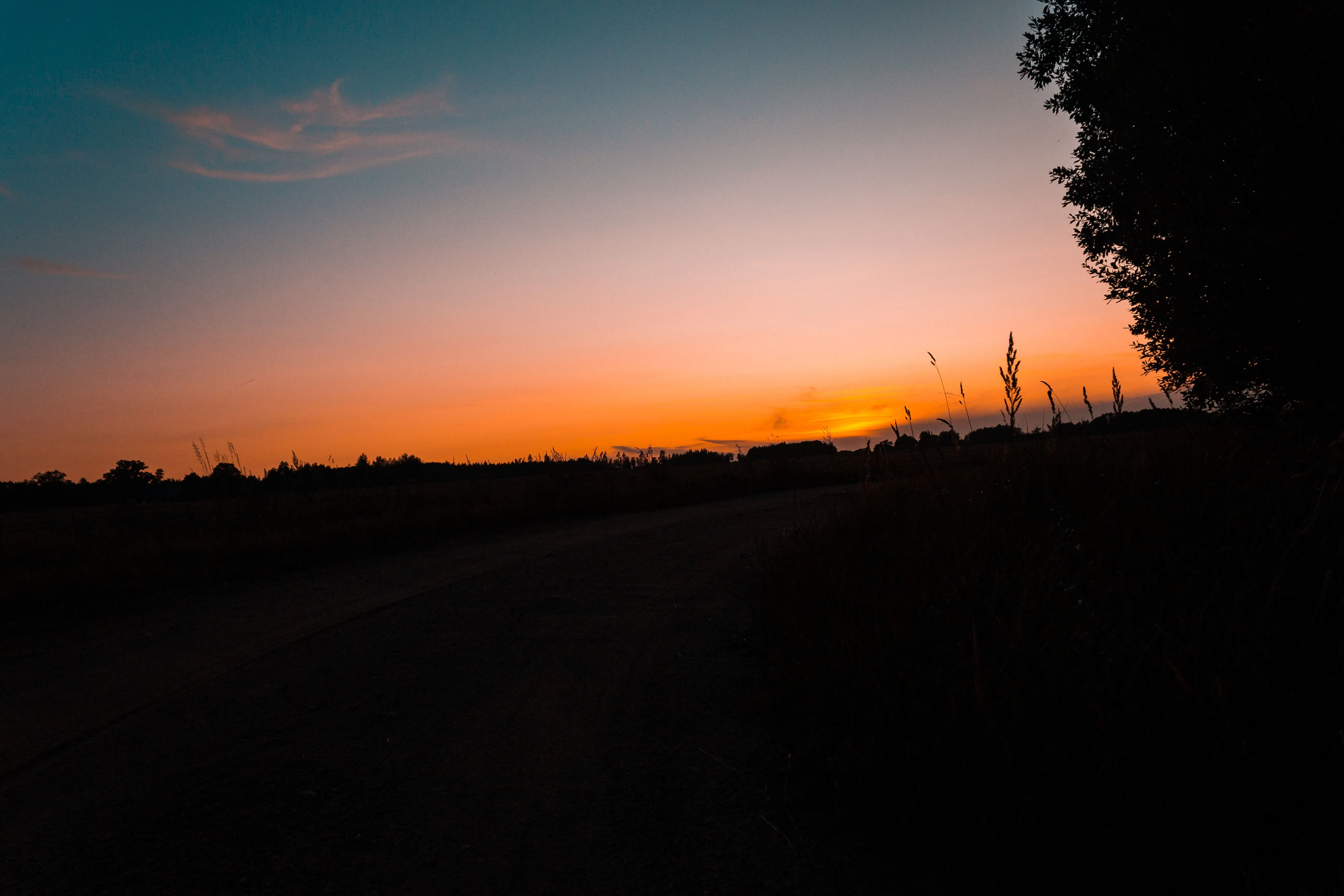 Serene sunset sky over a tranquil Lithuanian countryside landscape, showcasing the beauty of nature.
