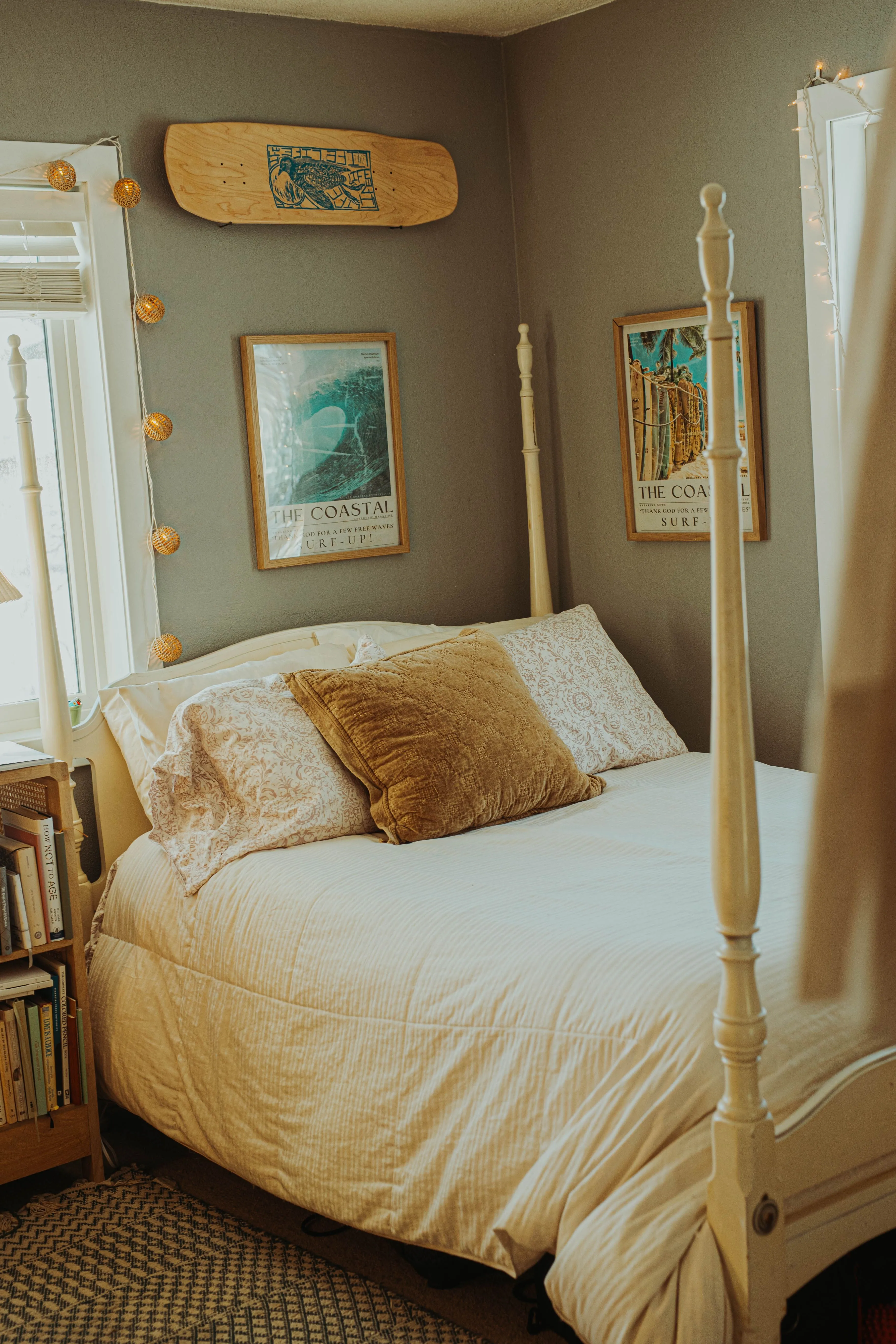A cozy bedroom interior with surf-themed decor, warm lighting, and soft textiles.