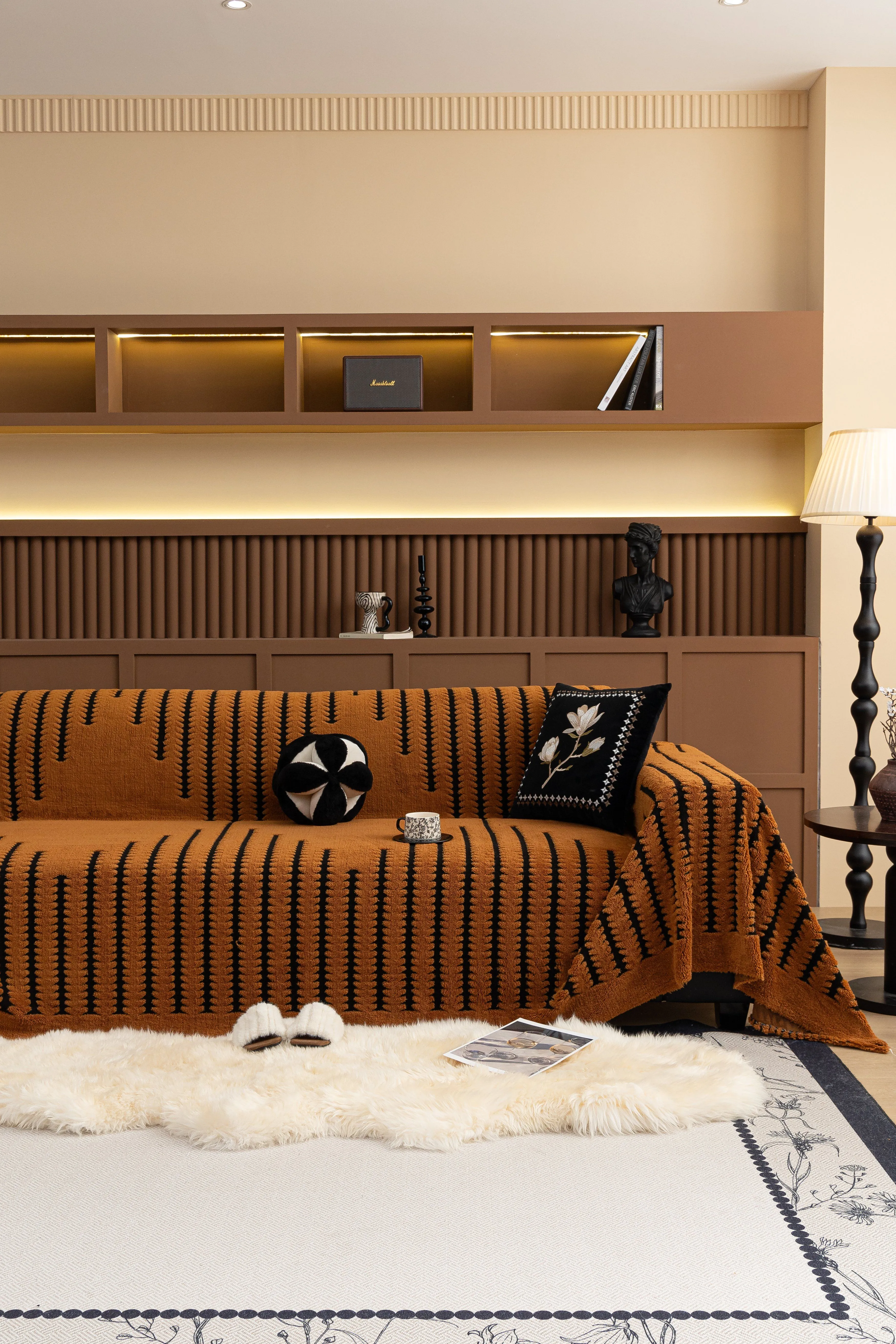 Cozy living room with sofa cover, decorative pillows, and modern interior design.