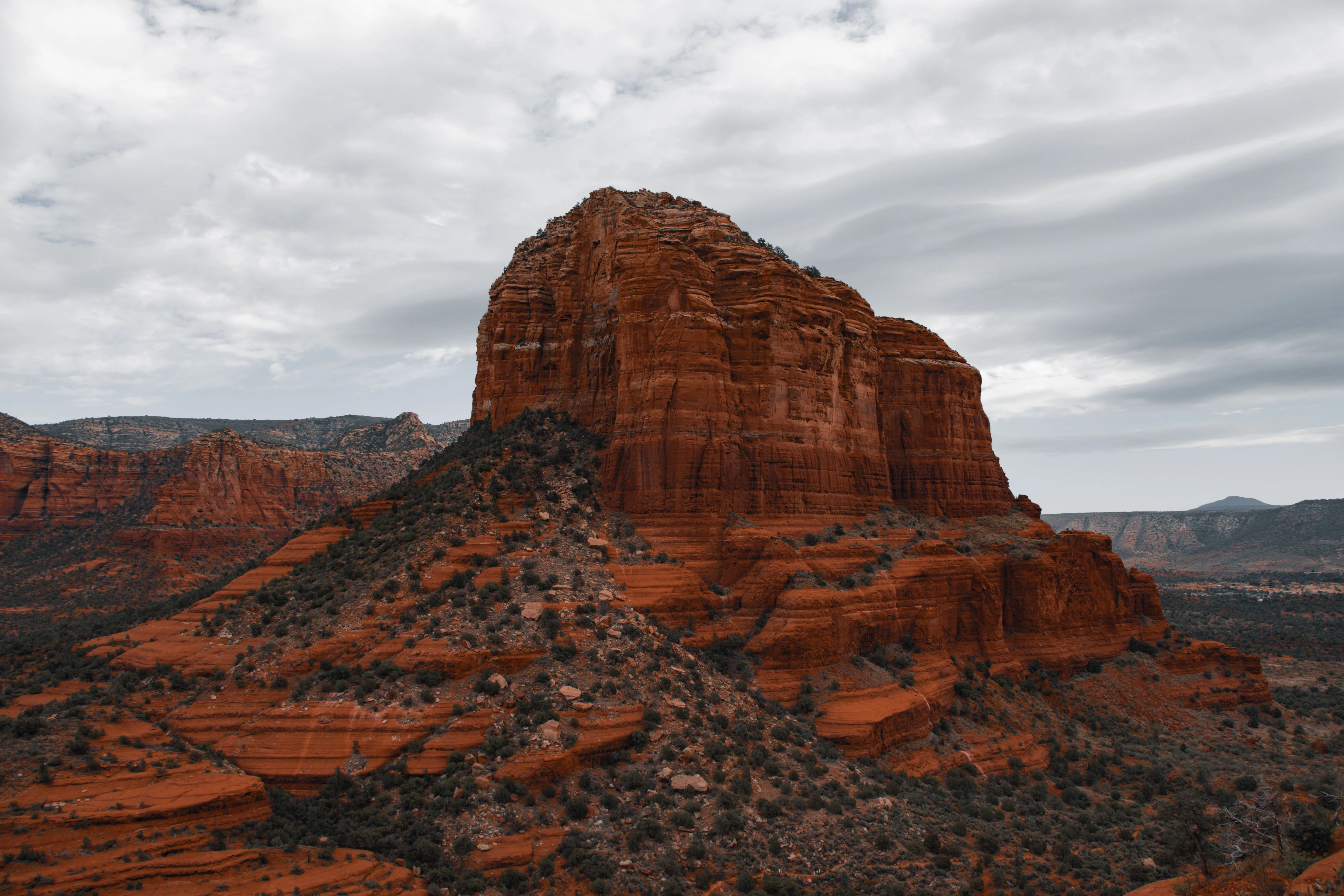Striking red rock mountain landscape in Sedona, Arizona under cloudy skies.
