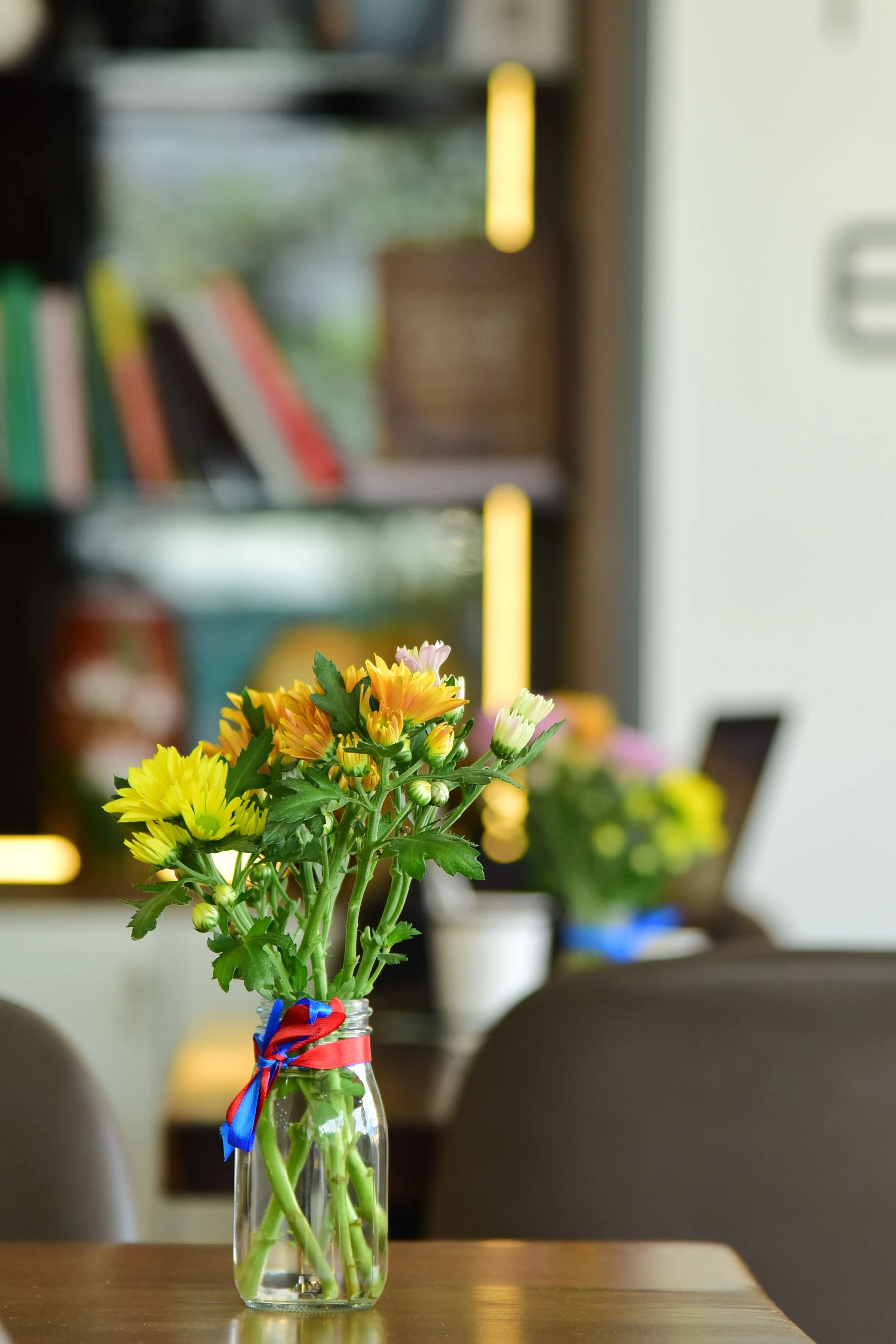 A bouquet of colorful chrysanthemums displayed in a clear glass vase, creating a lively indoor atmosphere.