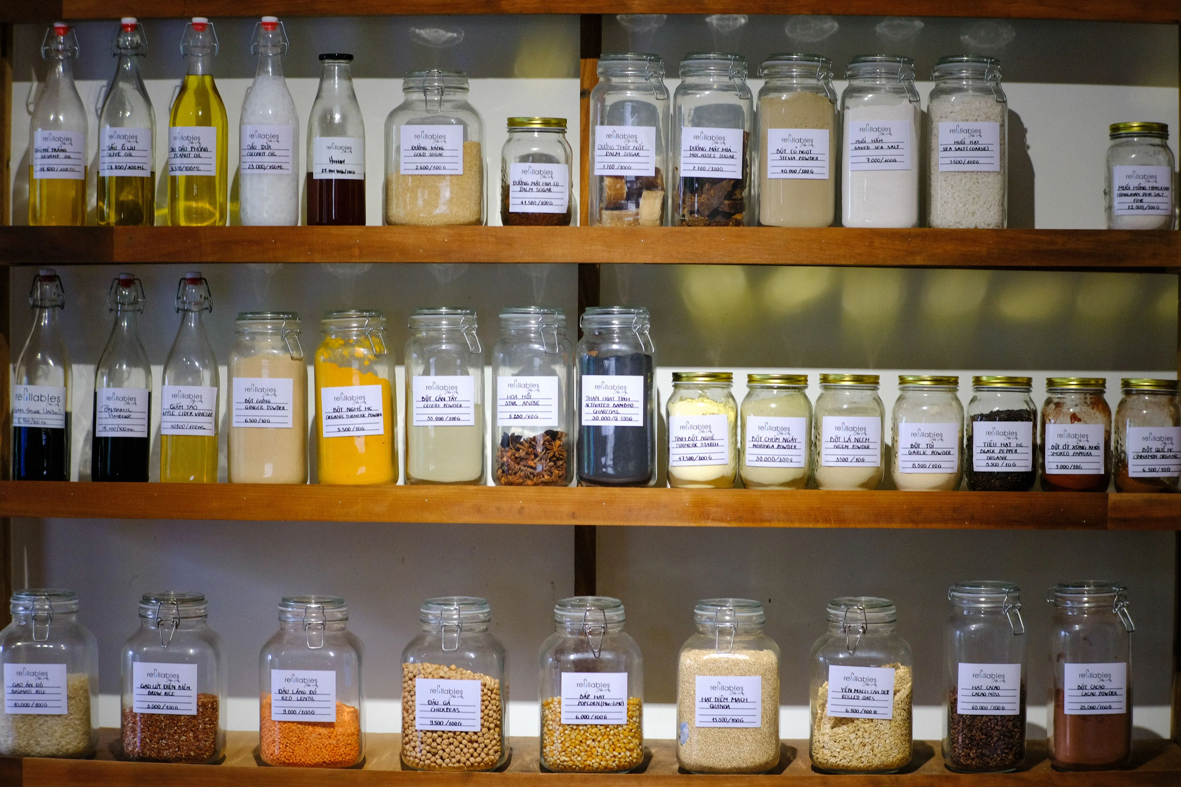 Variety of jars filled with different cooking ingredients neatly arranged on wooden shelves.